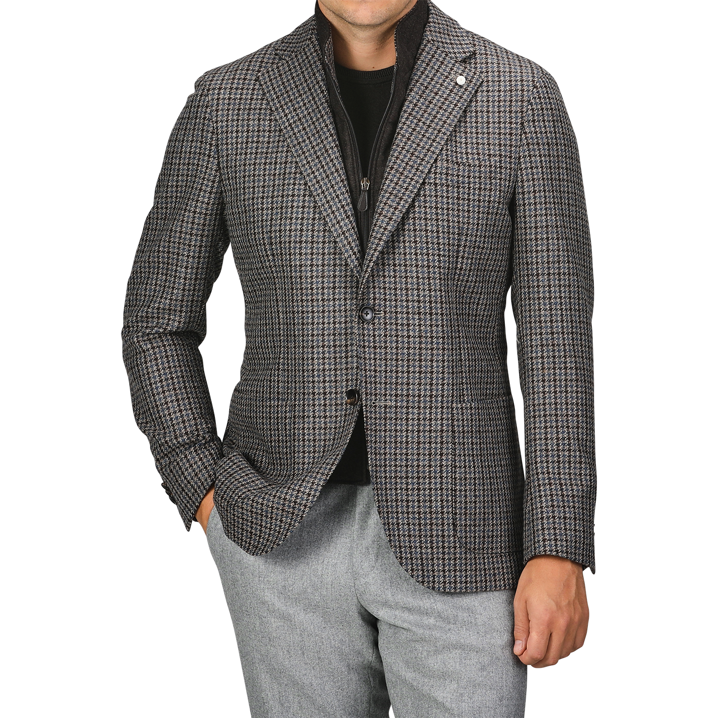 A person wearing a Luigi Bianchi brown houndstooth wool cashmere hybrid blazer over a black top, with grey pants. Their right hand is in their pocket. The person's head is not visible in the image.