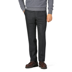 A person in a grey sweater and hands in pockets, wearing Luigi Bianchi Charcoal Grey Wool Flannel Flat Front Trousers with brown dress shoes.