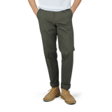A man in Luigi Bianchi dark green cotton twill flat front trousers and a white t-shirt.