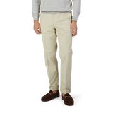A man in a regular fit beige sweater and Luigi Bianchi Light Beige Cotton Twill Flat Front Trousers.