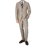 A man is posing in a Luigi Bianchi Light Brown Herringbone Linen Suit.