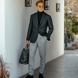 A man dressed in Luigi Bianchi's Light Grey Wool Flannel Pleated Trousers and a turtleneck.