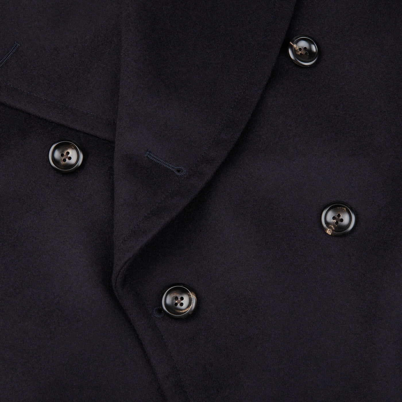 A close up image of a Luigi Bianchi navy blue double-breasted jacket with buttons.