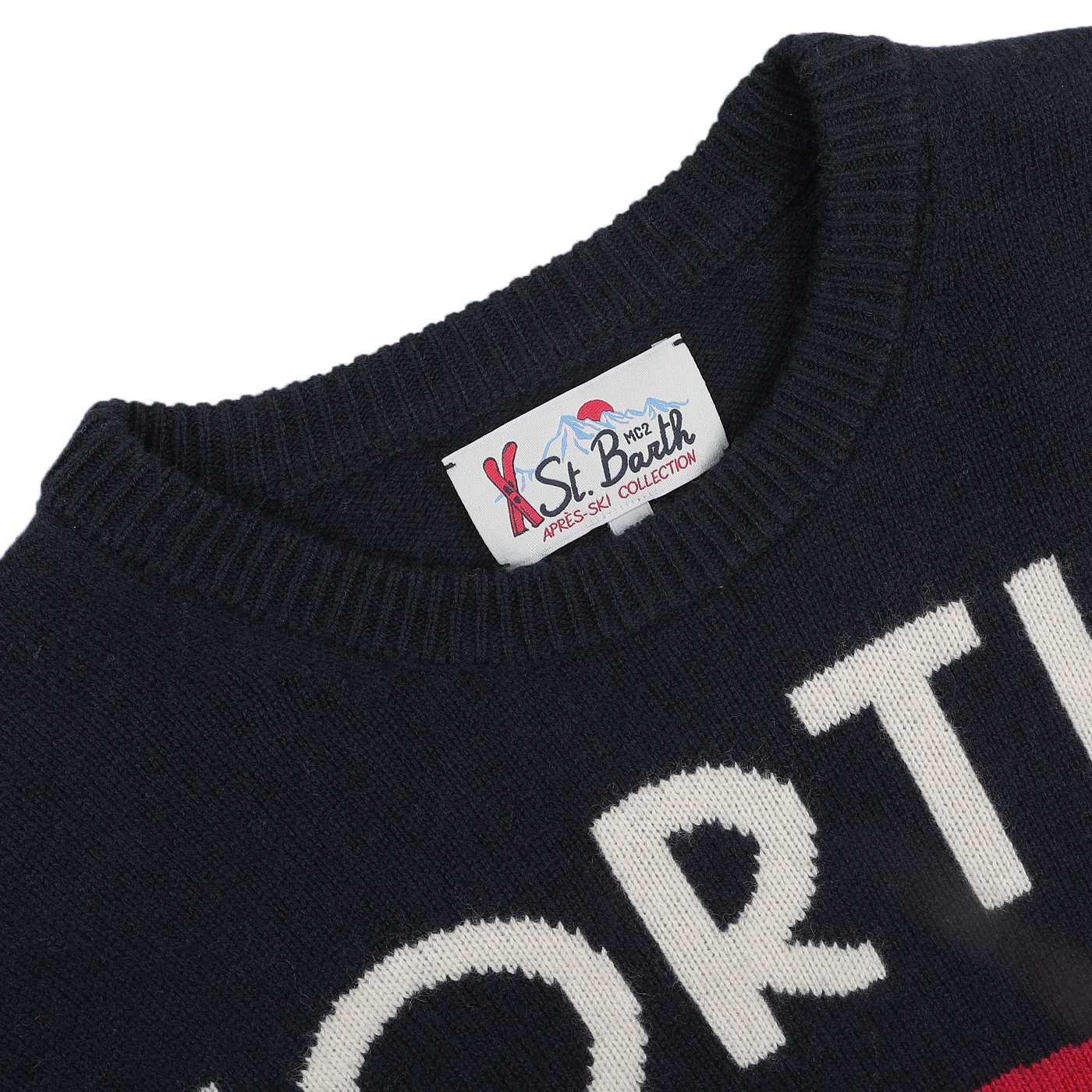 A close-up of a navy blue sweater with elegant white lettering and an MC2 Saint Barth label on the collar, capturing the cozy charm of our Aprés Ski Collection. It's the perfect choice for lounging in style after a day at ski resorts or savoring the winter magic of Cortina, Italy.