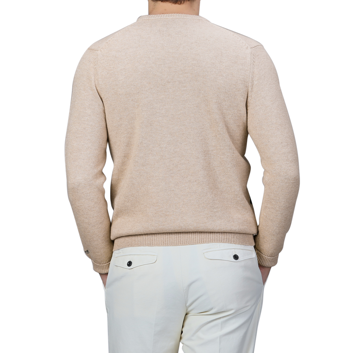 A person wearing the Beige Wool Cashmere Courchevel Sweater by MC2 Saint Barth combined with white pants is shown from the back against a plain background, capturing the cozy elegance of the Après Ski Collection—ideal for winter afternoons at ski resorts.