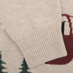 Close-up of the sleeve of the Beige Wool Cashmere Courchevel Sweater by MC2 Saint Barth, showcasing a ribbed cuff and a partial red reindeer and green pine trees pattern from our Aprés Ski Collection. Ideal for cozy nights in Courchevel's charming ski resorts.