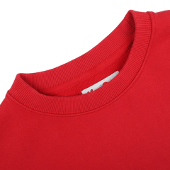 Close-up of the MC2 Saint Barth Bright Red Cotton Courchevel Sweater's neckline on a gray background, highlighting ribbed detailing and a small visible tag inside, evoking cozy evenings at après-ski in Courchevel.