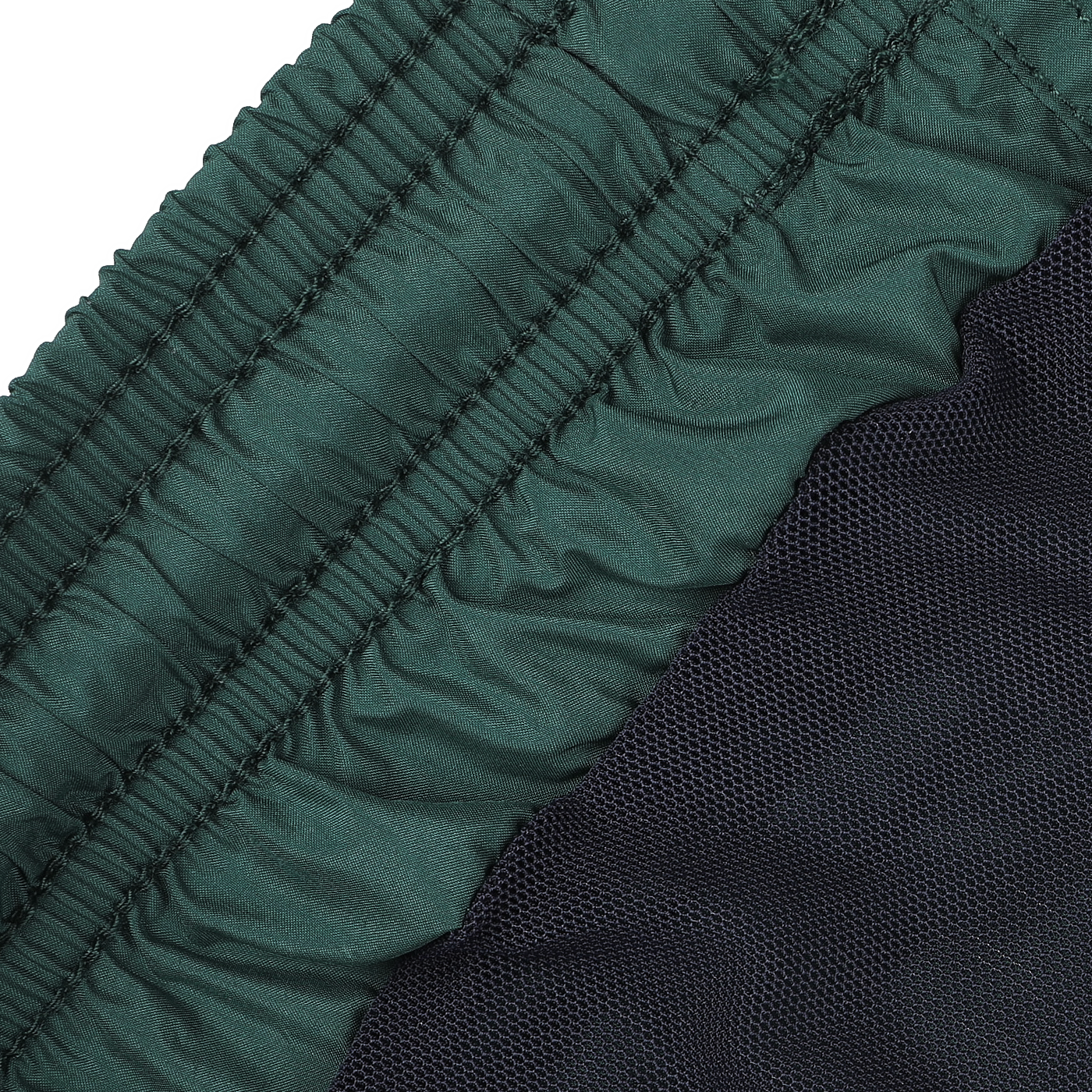 A detailed view of the British Green Pantone 18-5315 fabric featuring elastic ruching, alongside a black mesh material, reminiscent of MC2 Saint Barth swim shorts.