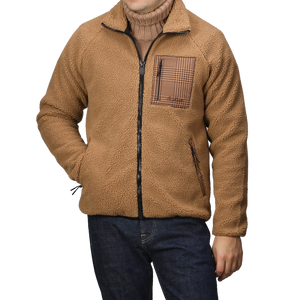 A person wearing an MC2 Saint Barth Camel Beige Sherpa Fleece Jacket with houndstooth details and blue jeans.