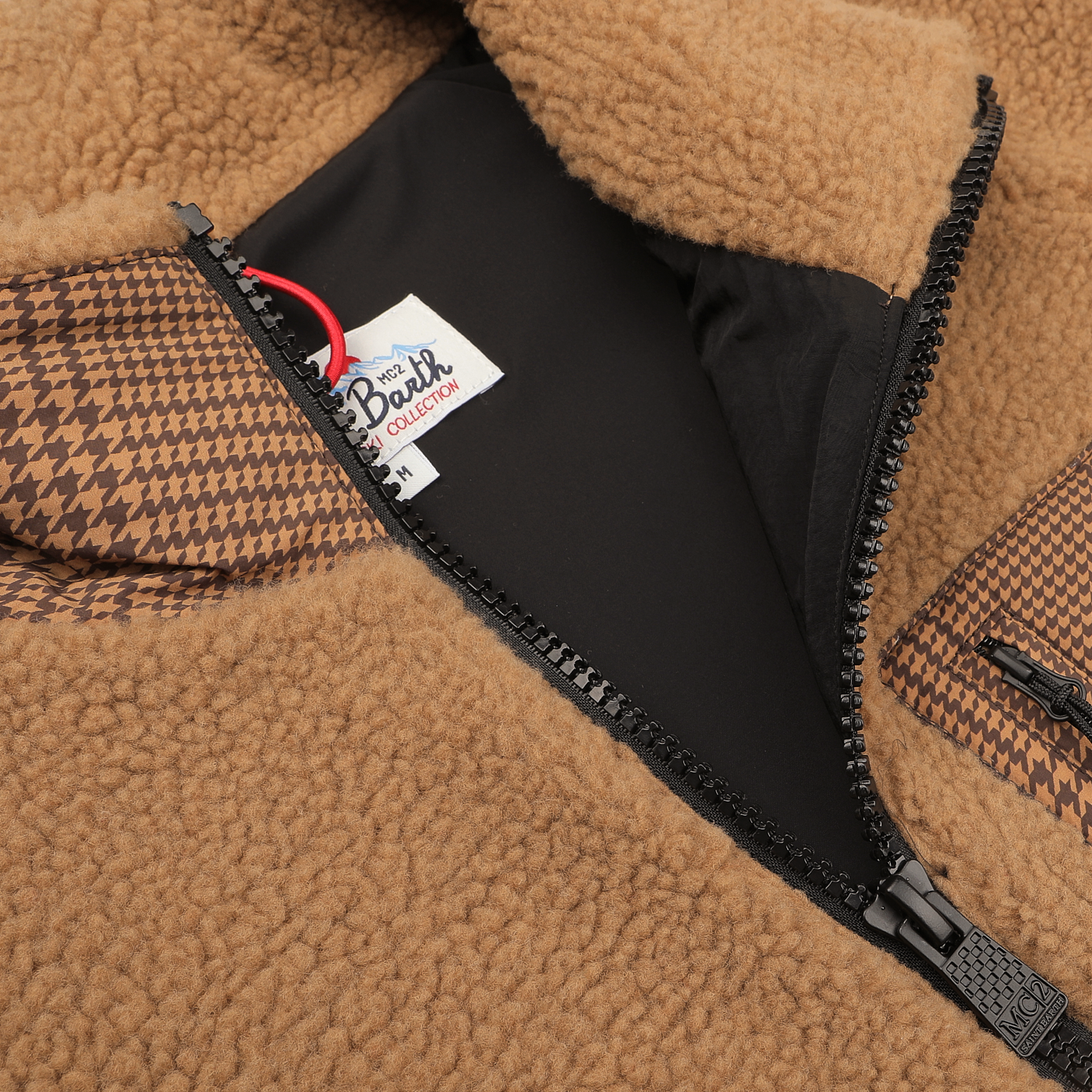 Close-up of the Camel Beige Sherpa Fleece Jacket by MC2 Saint Barth, featuring black houndstooth details and a partially open zipper that reveals a label inside.