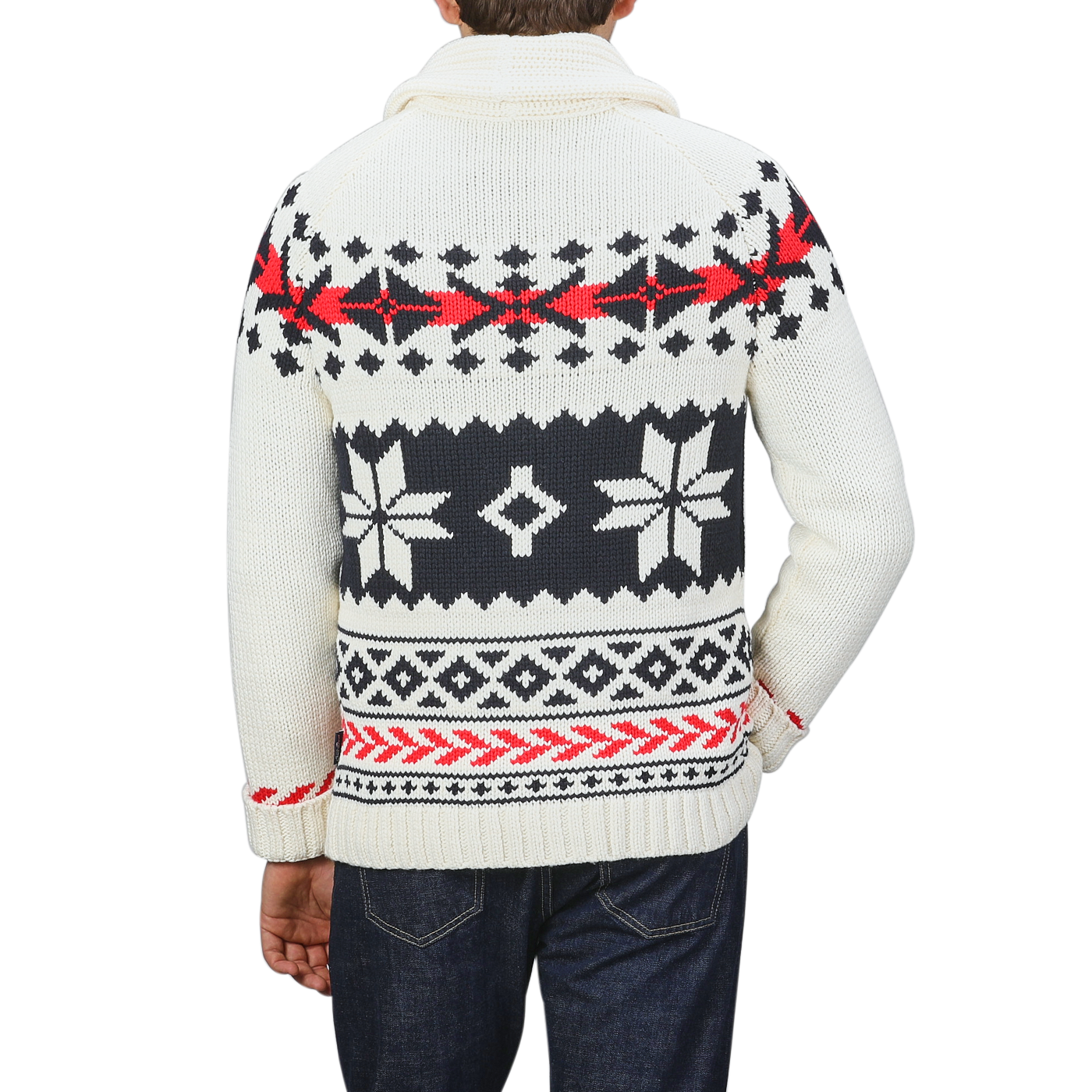 A person is seen from the back, wearing a Cream White Wool Nordic Aztec Cardigan by MC2 Saint Barth. The sweater features a white and black patterned design with red accents, paired with a shawl collar, all crafted from a cozy wool-blend. This stylish piece embodies the aesthetic of an Archer Nordic Aztec cardigan.