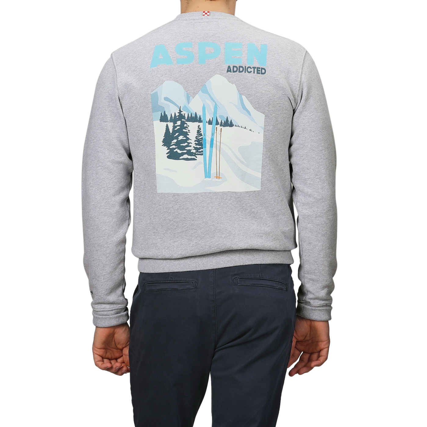 Someone is wearing the Grey Melange Cotton Aspen Sweater by MC2 Saint Barth, featuring a graphic of snowy mountains, trees, and ski poles. The phrase "Aspen Addicted" above the image perfectly captures the essence of Aspen ski resorts, ideal for those "Aprés Ski" moments.