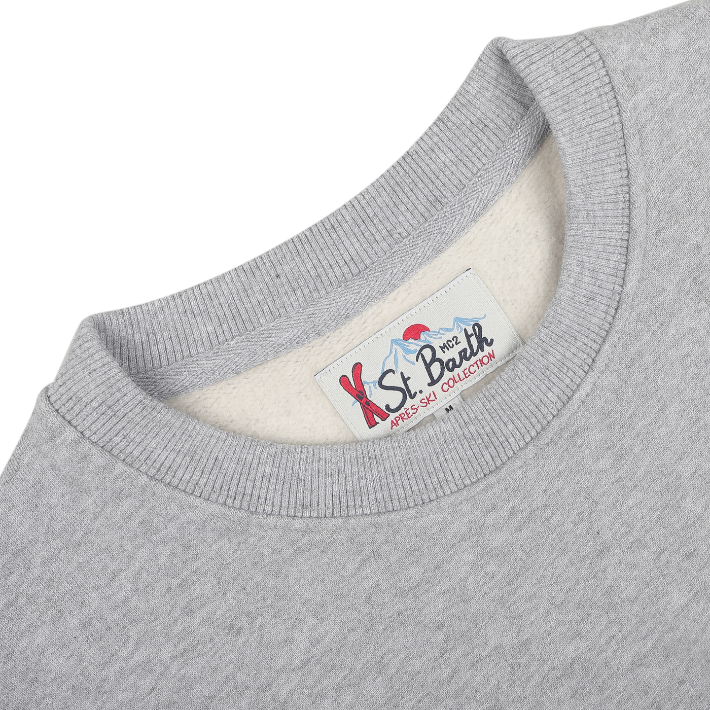 Close-up of a cozy cotton sweater collar with a label reading "MC2 Saint Barth, Grey Melange Cotton Aspen Sweater" in blue and red text, perfect for lounging at Aspen ski resorts.