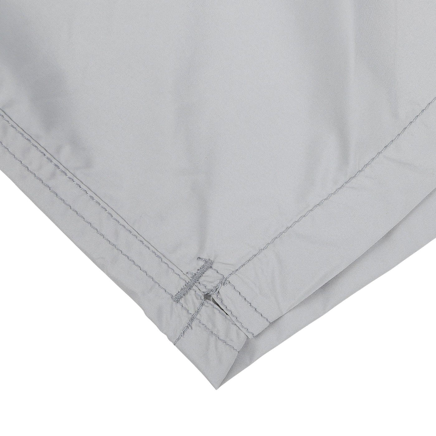 The image highlights the corner of MC2 Saint Barth's Light Grey Pantone 15-4307 Swim Shorts, showcasing the visible stitching and folded hem made from quick-drying fabric, all set against a white background.