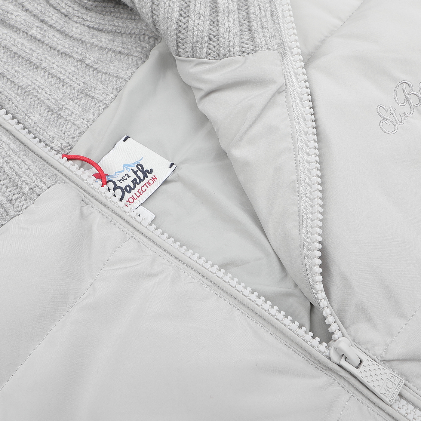 Close-up of the Light Grey Wool Whistler Padded Jacket by MC2 Saint Barth, featuring a zippered opening that reveals a "My First Bebe Collection" label inside.