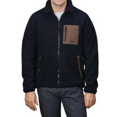 A man wearing the MC2 Saint Barth Navy Blue Sherpa Fleece Jacket showcases a zip-up front, complemented by a camel beige houndstooth patterned chest pocket and matching side pockets.