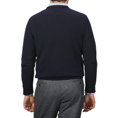 A person wearing an MC2 Saint Barth Navy Blue Wool Cashmere Aprés Ski Sweater and gray trousers is shown from the back, capturing the cozy elegance of the Après Ski Collection.