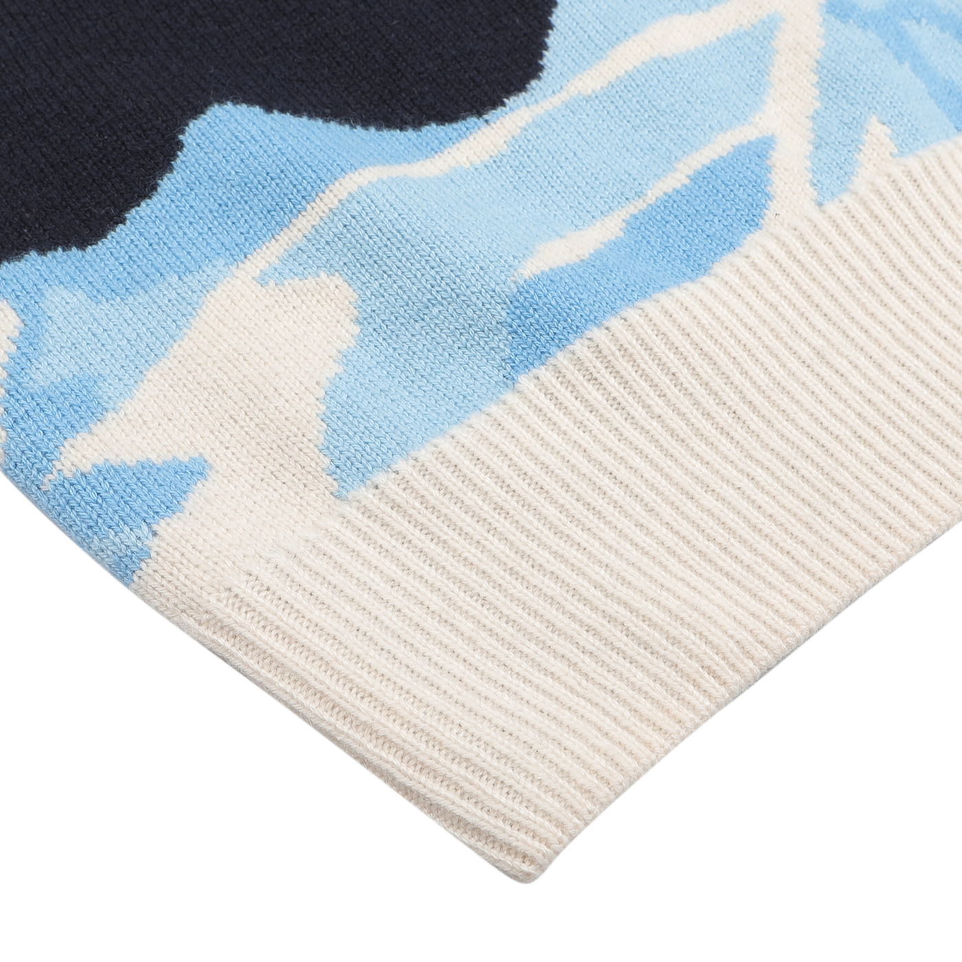 Close-up of the Navy Wool Cashmere Cortina Sweater from MC2 Saint Barth, showcasing a blue and black abstract pattern with a white ribbed edge, inspired by the chic ski resorts of Cortina, Italy.