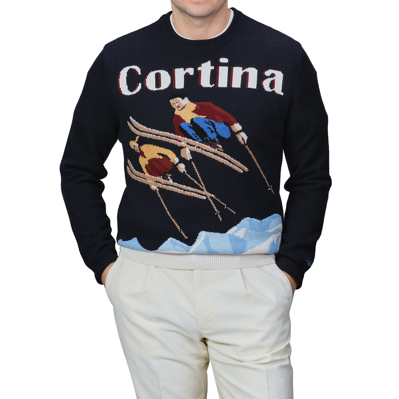 A person stands against a plain background, wearing white pants and the MC2 Saint Barth Navy Wool Cashmere Cortina Sweater, highlighting the spirit of Cortina Italy's ski resorts from the Après Ski Collection.