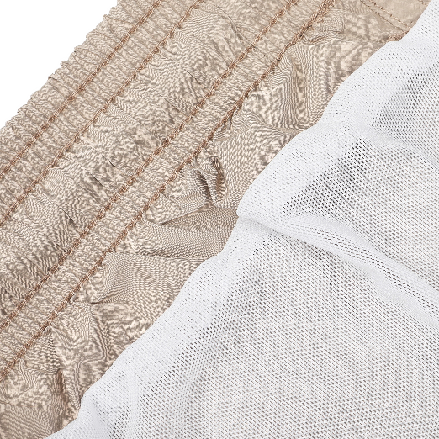 A close-up of the Safari Beige Pantone 15-1116 Swim Shorts by MC2 Saint Barth highlights the ruched quick-drying fabric alongside white mesh fabric.