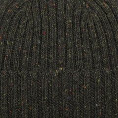 A close-up of the Dark Green Melange Wool Donegal Beanie by Mackie reveals a dark green mélange knit fabric with multicolored specks and a ribbed texture, evoking traditional Donegal wool craftsmanship.