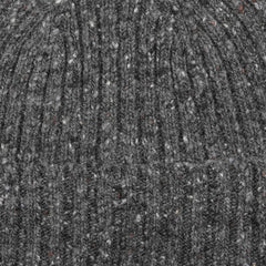 Close-up of a textured Scottish knitwear fabric, showcasing a ribbed pattern with a mix of light and dark gray fibers similar to the Mackie Grey Melange Wool Donegal Beanie.