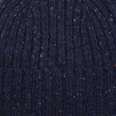 Close-up of a Mackie Navy Blue Melange Wool Donegal Beanie, showcasing its textured knit with speckles of orange and blue.