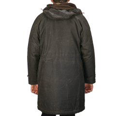 Back view of a person wearing the Dark Green Waxed Cotton Mountain Parka with hood and wool padding by Manifattura Ceccarelli.