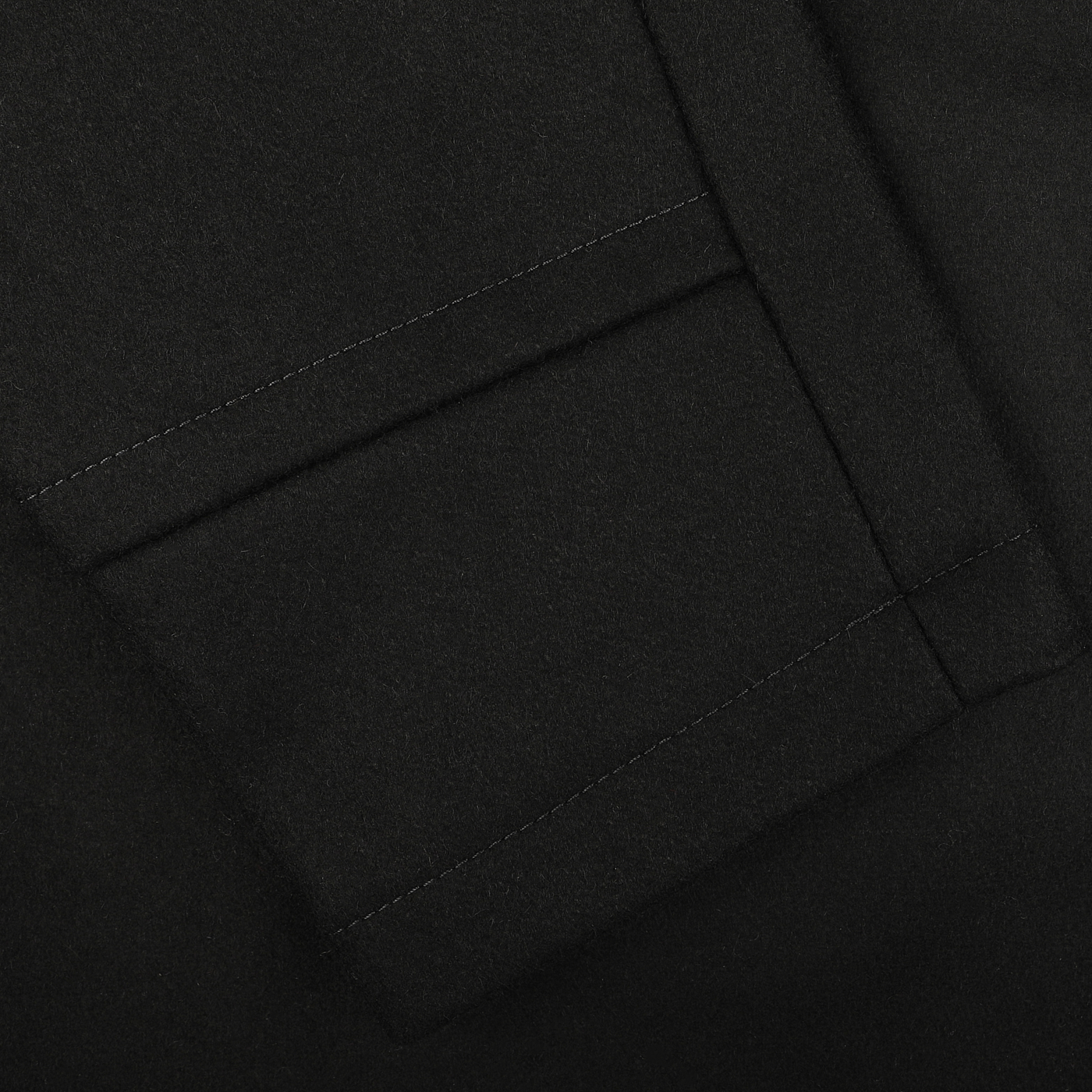 Close-up of a dark navy fabric with a neatly sewn pocket featuring clean, straight stitching and a sharp fold. This heavy wool blend, the Dark Navy Heavy Wool Peacoat by Manifattura Ceccarelli, ensures durability and style akin to a classic peacoat.