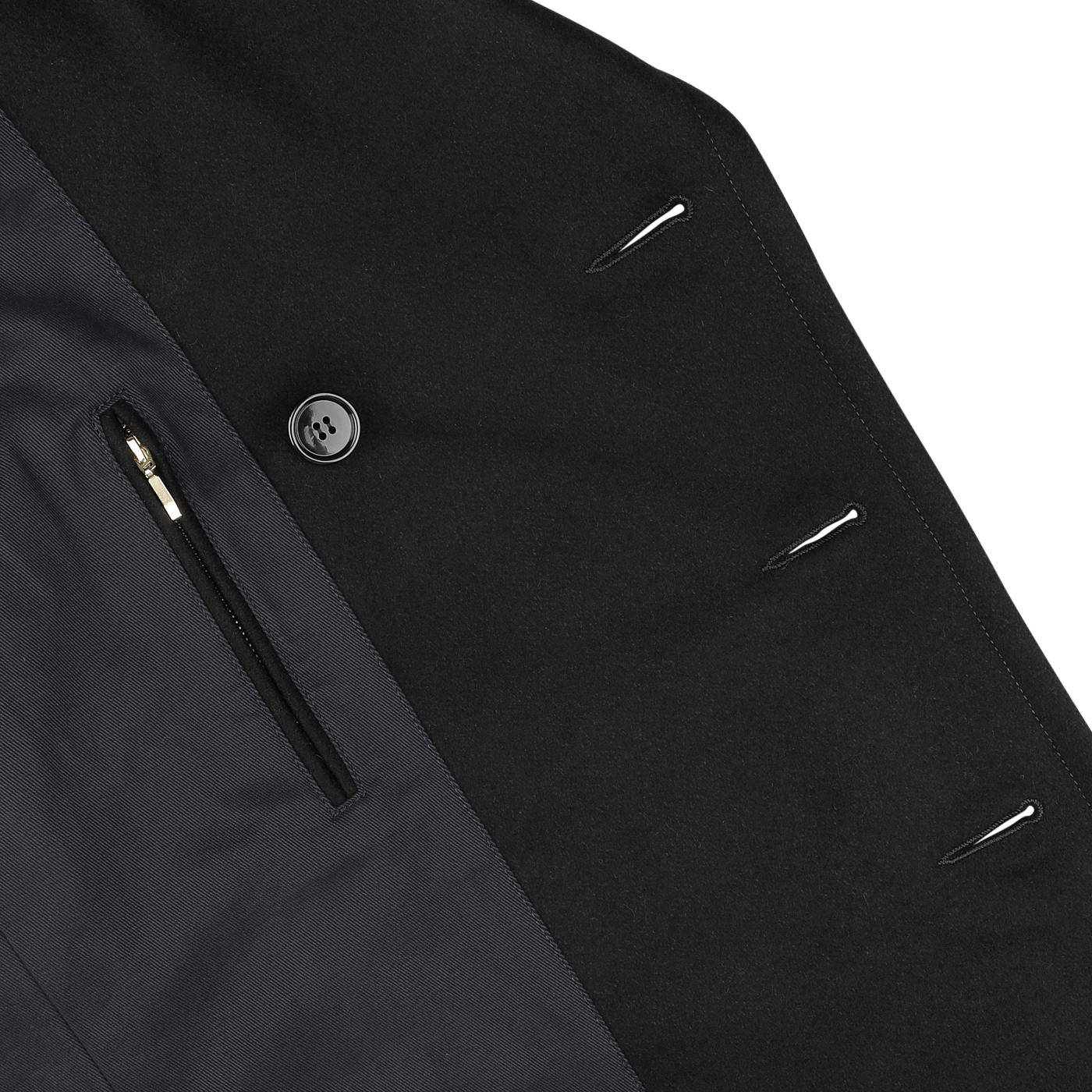 Detail of a dark navy heavy wool peacoat with one visible button, a horizontal zip pocket, and buttonholes on the lapel. Channeling the craftsmanship of Manifattura Ceccarelli, this piece reflects attention to detail and elegance.