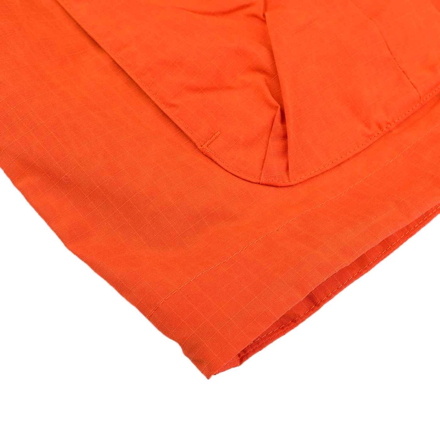 Close-up of an Orange Cotton Nylon Ripstop All Seasons Blazer Coat sleeve by Manifattura Ceccarelli, featuring visible stitching and a checkered pattern on durable Rip-Stop fabric.