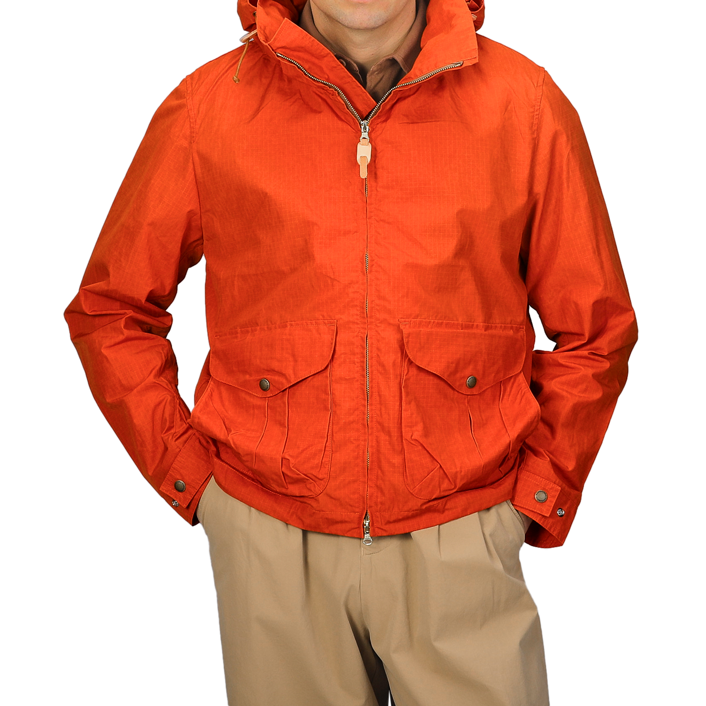 A person is wearing the Manifattura Ceccarelli Orange Cotton Nylon Ripstop All Seasons Blazer Coat with a hood, zipper, and two front pockets over tan pants. The jacket boasts a detachable lining for versatility in different weather conditions.