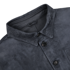 Close-up of the Manto Denim Blue Suede Unlined Jacket featuring a collared design with four black buttons and a visible chest pocket.