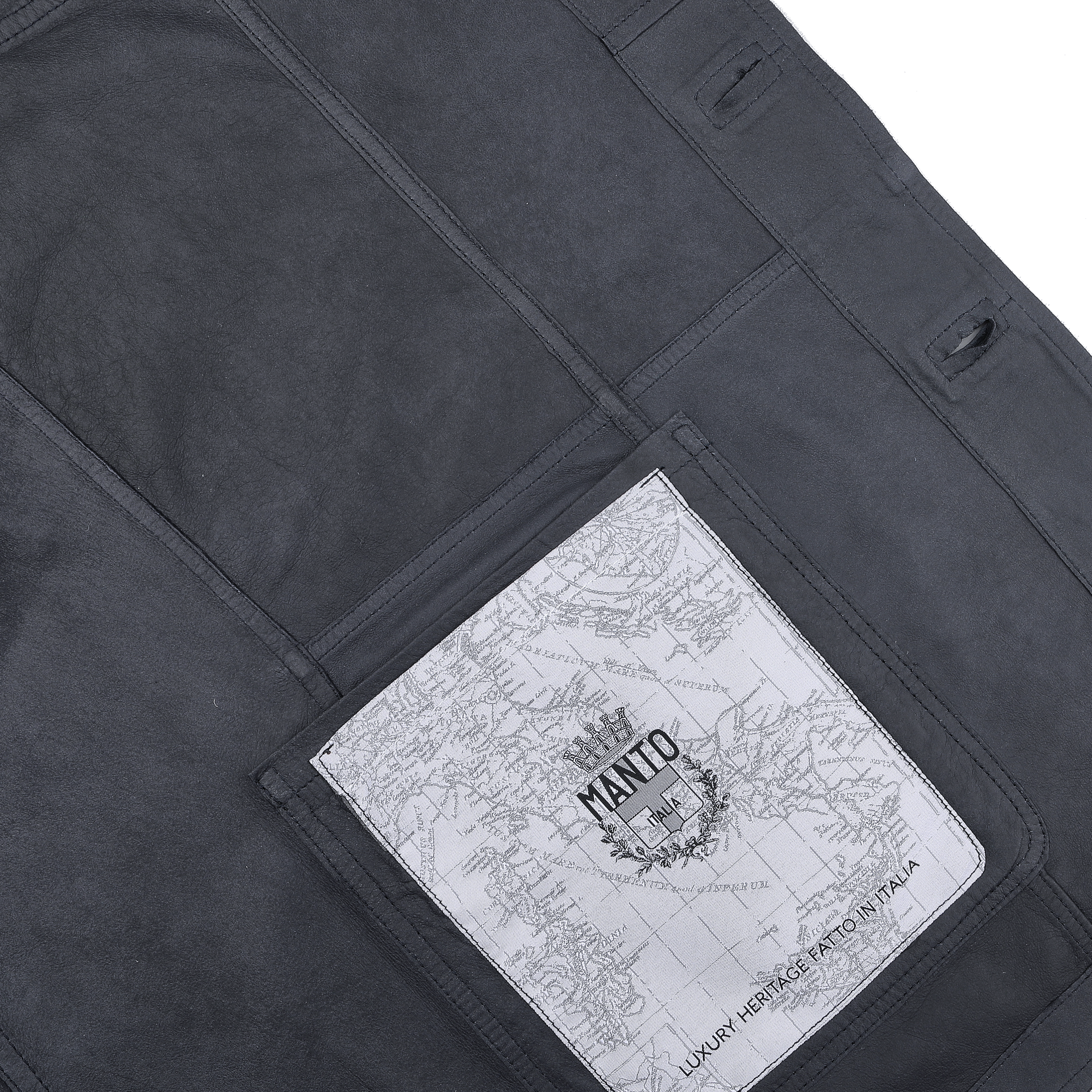 Close-up of a Denim Blue Suede Unlined Jacket by Manto, featuring a map printed on a white rectangular pocket. Text reads "Manto" with additional decorative elements, seamlessly blending rugged style and modern detail.