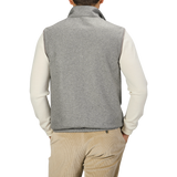 A person wearing a Manto Grey Beige Cashmere Nylon Reversible Gilet over a white long-sleeve shirt and beige corduroy pants stands with their back to the camera.