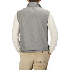 A person wearing a Manto Grey Beige Cashmere Nylon Reversible Gilet over a white long-sleeve shirt and beige corduroy pants stands with their back to the camera.