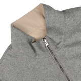 A close-up of the Manto Grey Beige Cashmere Nylon Reversible Gilet, showcasing its luxurious beige lining. The gilet is partially unzipped and lying flat on a light-colored surface.