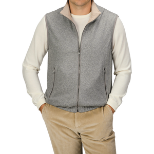 A person wearing a Manto Grey Beige Cashmere Nylon Reversible Gilet over a white long-sleeve shirt and beige corduroy pants stands against a plain background.