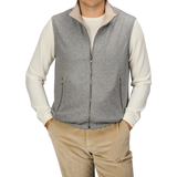 A person wearing a Manto Grey Beige Cashmere Nylon Reversible Gilet over a white long-sleeve shirt and beige corduroy pants stands against a plain background.