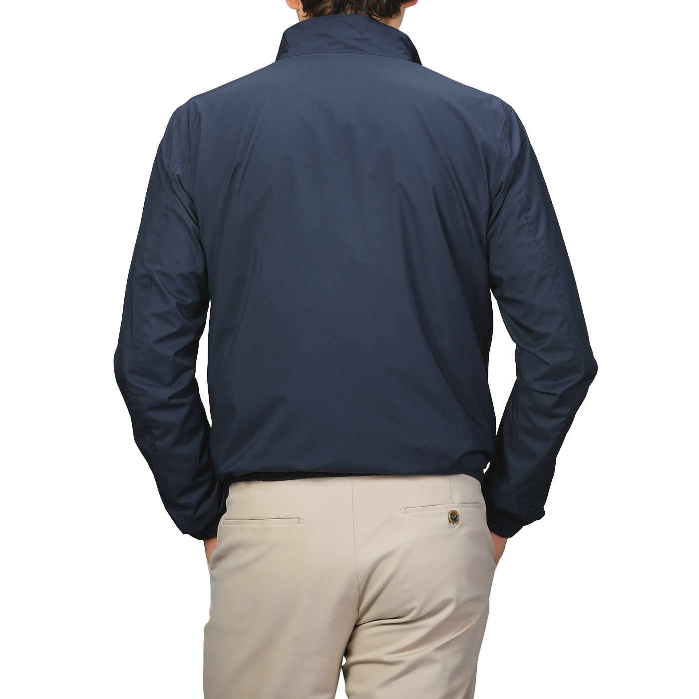 The person, facing away, is dressed in a Manto Navy Beige Reversible Nylon Blouson paired with beige pants.