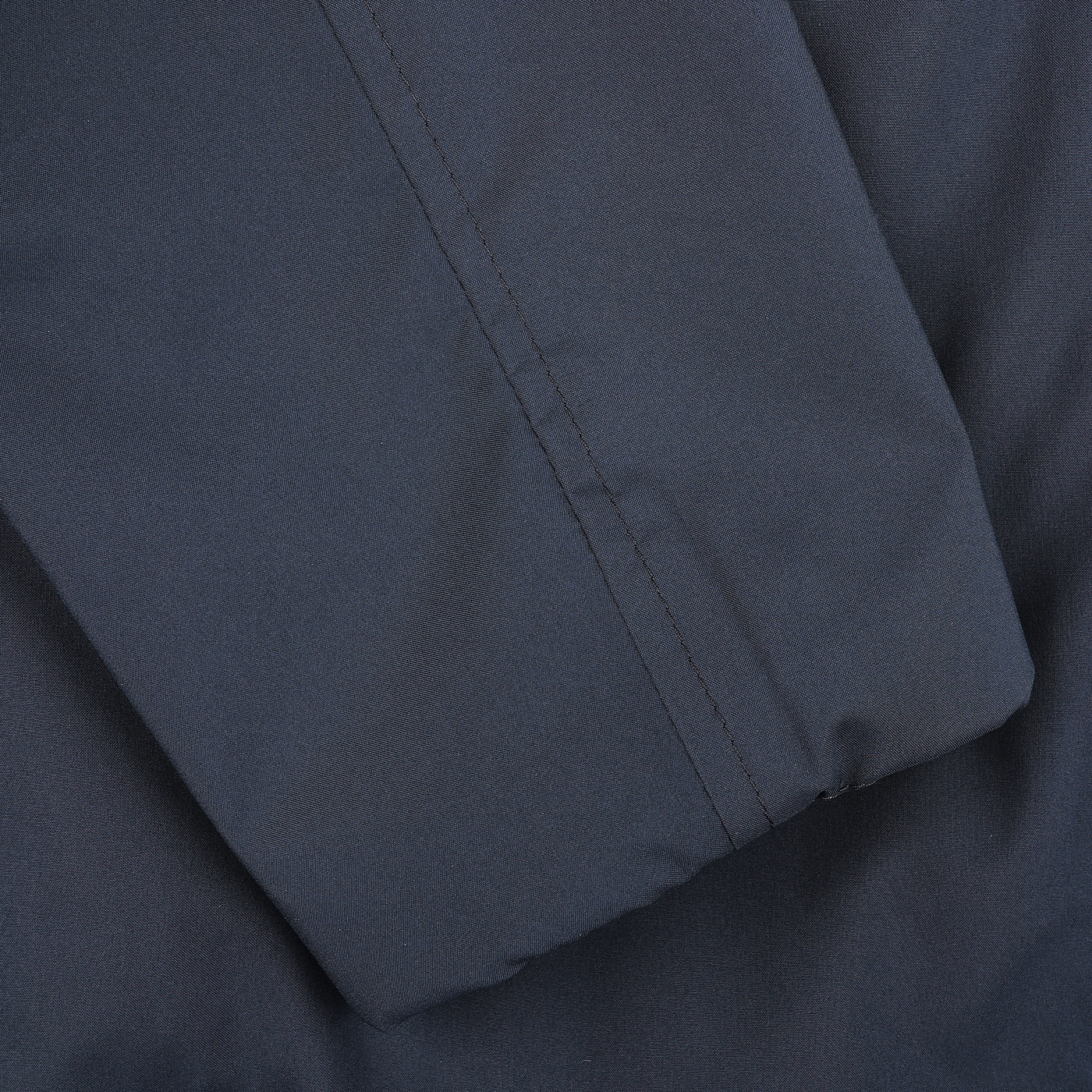 Close-up of Manto's Navy Beige Reversible Nylon Blouson, showcasing visible seam stitching on smooth yet slightly textured water-resistant nylon.