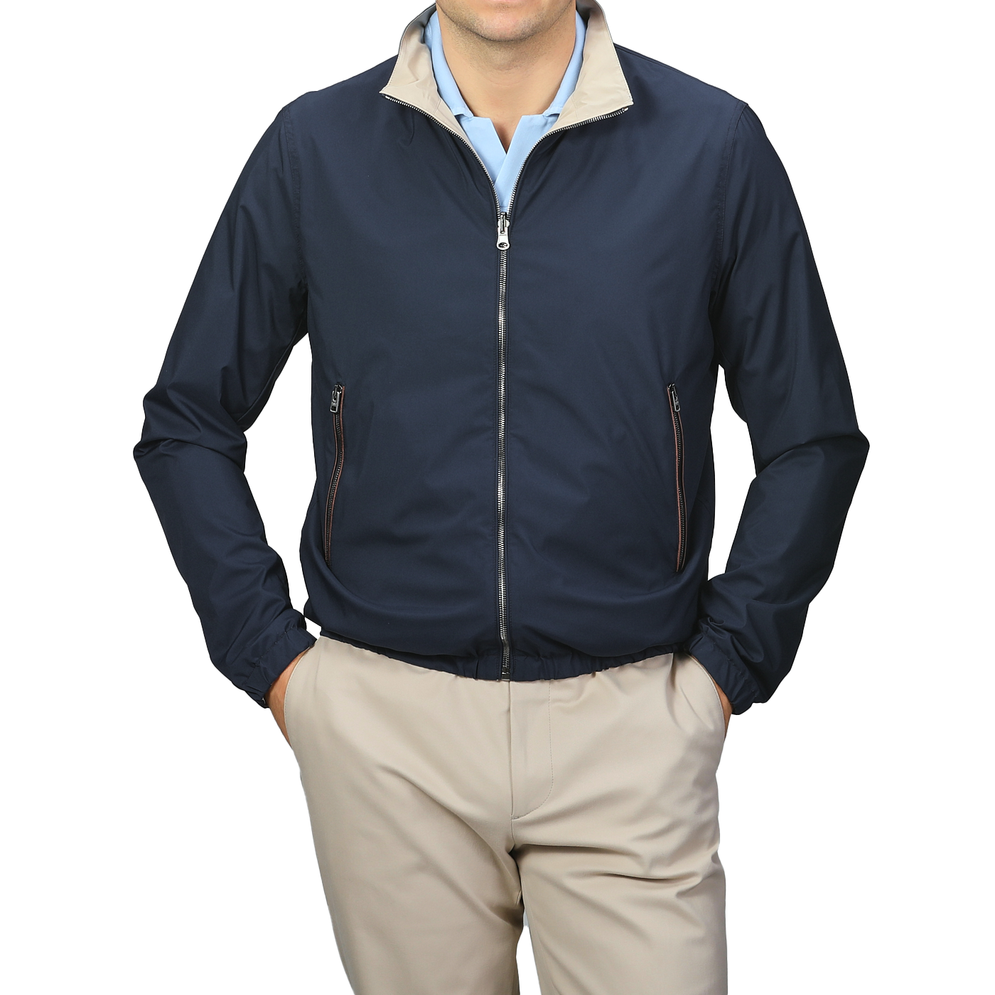 A person is wearing the Manto Navy Beige Reversible Nylon Blouson, featuring a beige collar, and matching beige pants. The slim-fit, water-resistant jacket is zipped up with hands in the pockets.