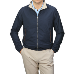 A person is wearing the Manto Navy Beige Reversible Nylon Blouson, featuring a beige collar, and matching beige pants. The slim-fit, water-resistant jacket is zipped up with hands in the pockets.