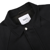 Close-up of the **Navy Blue Cashmere Car Coat** by **Manto**, featuring a pointed collar and a single front button. The label inside reads "Manto Italy." The luxurious cashmere outer exudes sophistication.