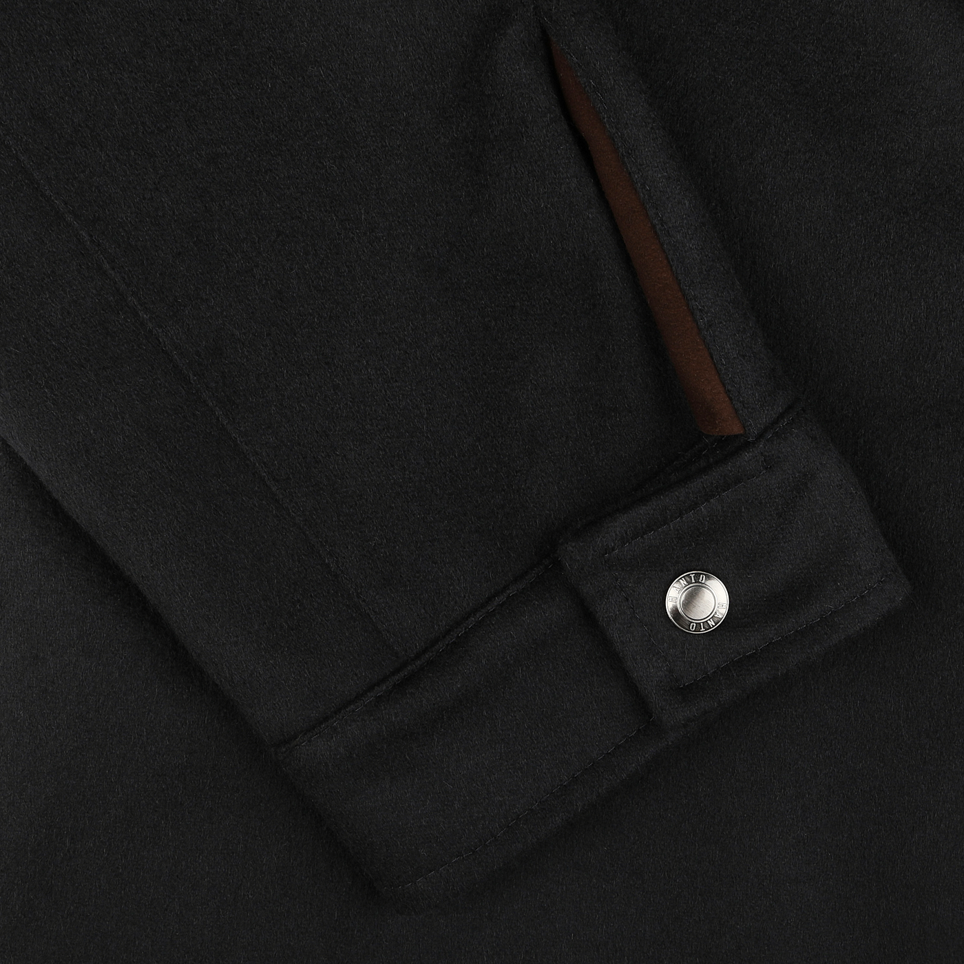 Close-up of the Manto Navy Blue Cashmere Car Coat sleeve, featuring a silver snap button on the cuff and a slit pocket with brown lining.