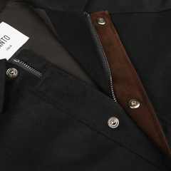 Close-up of Manto's Navy Blue Cashmere Car Coat's inner chest area, featuring the zipper, brown fabric lining, and metal snap buttons. A label stating "MADE IN ITALY" is also visible.