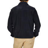 The back view of a man wearing a Manto Navy Blue Suede Leather Overshirt and tan pants.