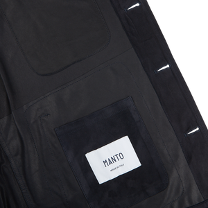 The back of a Manto navy blue suede leather overshirt with a label on it.