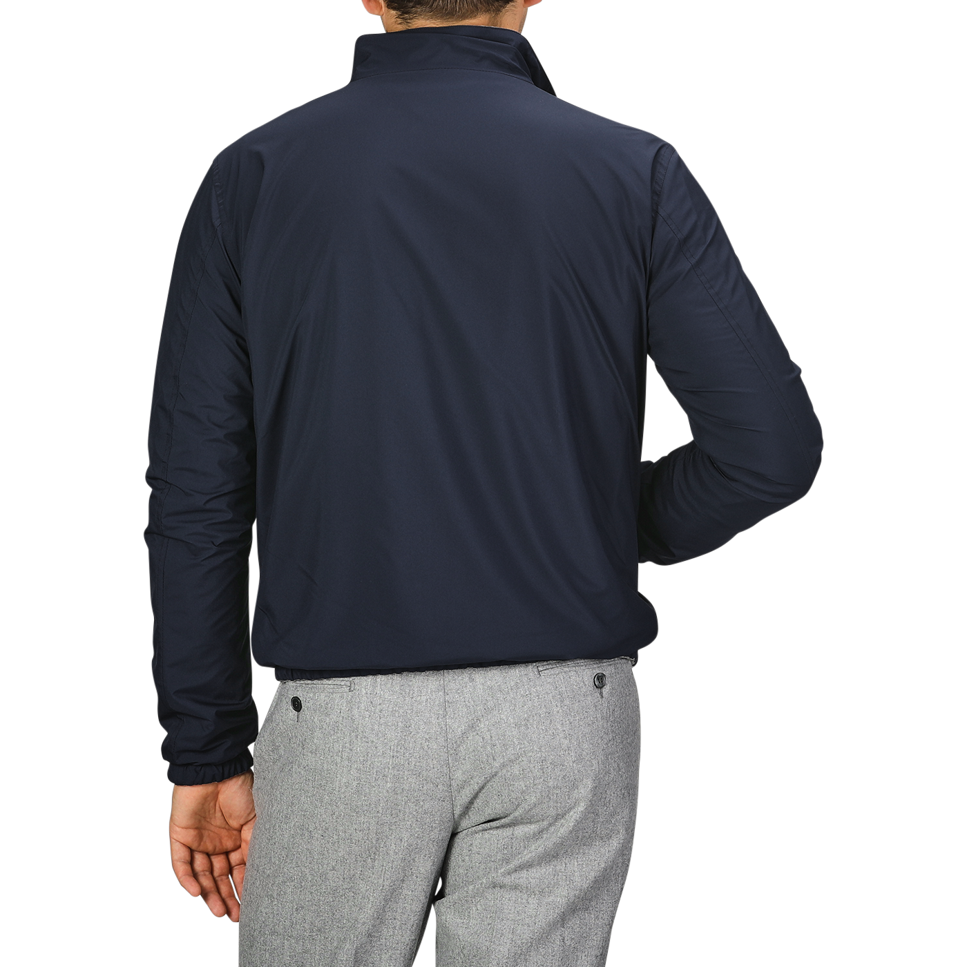 A man is shown from the back, standing against a plain gray background, wearing Manto's Navy Grey Cashmere Nylon Reversible Blouson and light gray pants.