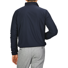 A man is shown from the back, standing against a plain gray background, wearing Manto's Navy Grey Cashmere Nylon Reversible Blouson and light gray pants.